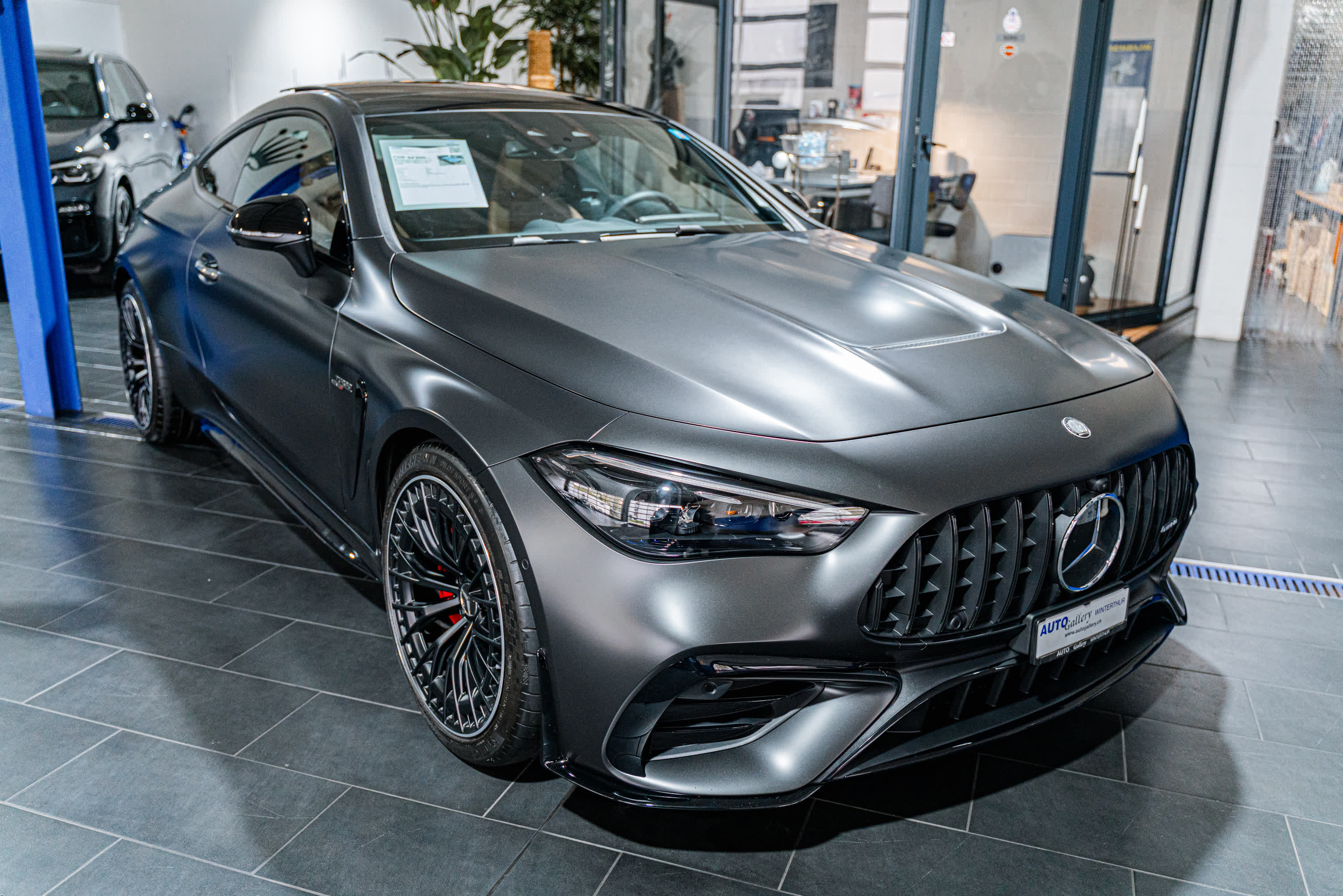 Mattgraues Mercedes-AMG Coupé im Showroom der Auto Gallery Winterthur